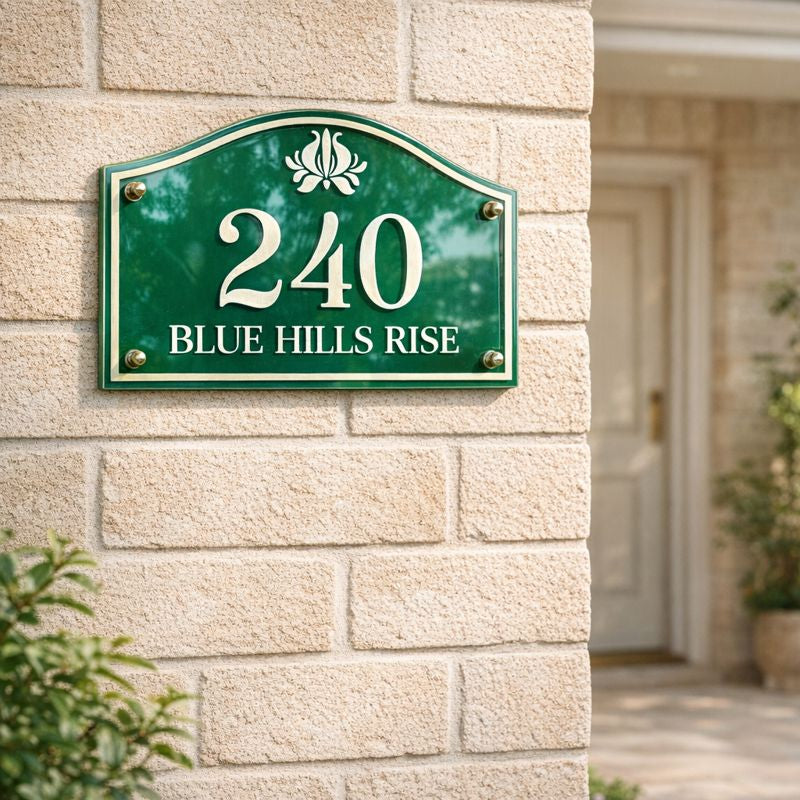 Heritage Petite compact house number sign in green with white numerals 240 and street name Blue Hills Rise mounted on a light brick wall