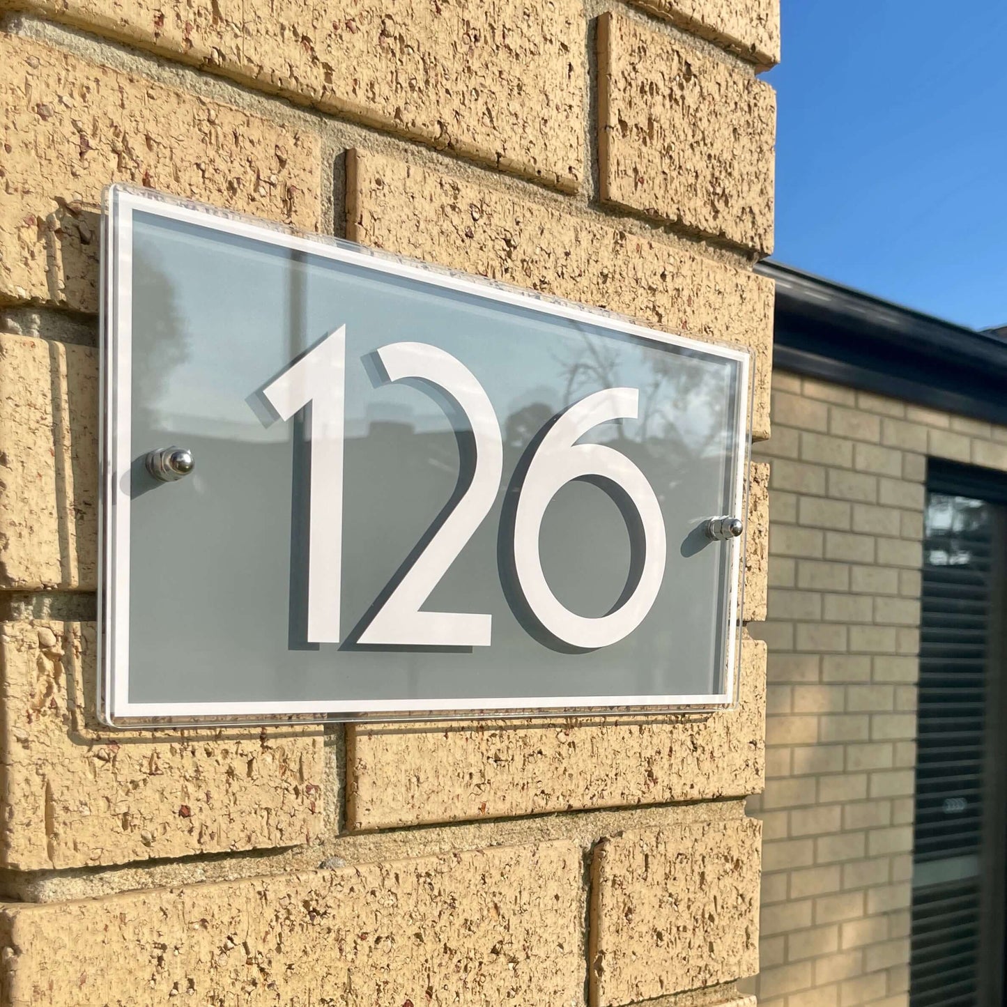 Australian made SW2 house number sign "126" mounted on brick wall