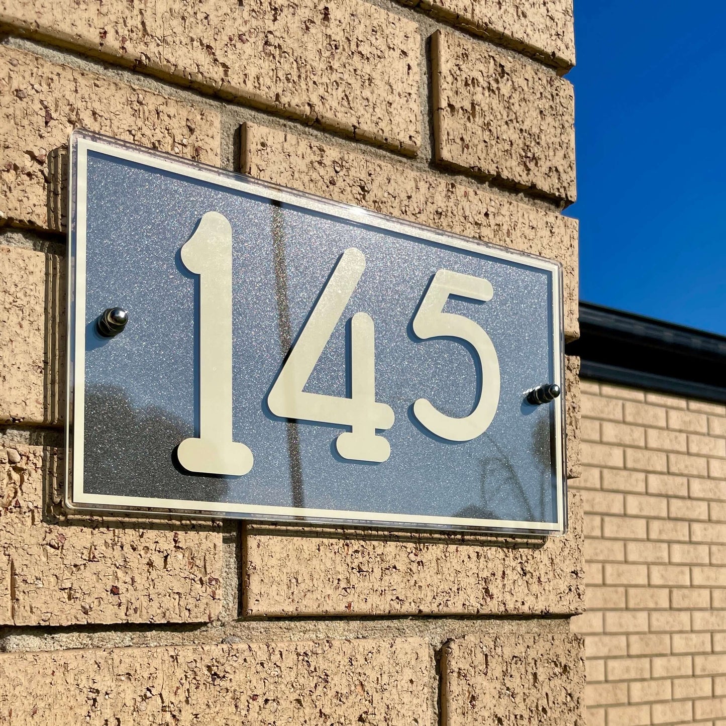 Australian made Urban 2 SW2 house number sign on brick wall. Simple installation with peel-and-stick UHB tape. Perfect for 3 numbers.