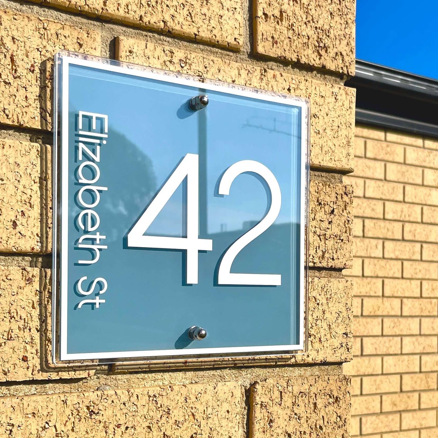Modern Australian-made house number sign mounted on brick, featuring '42 Elizabeth St', ideal for clear street identification.