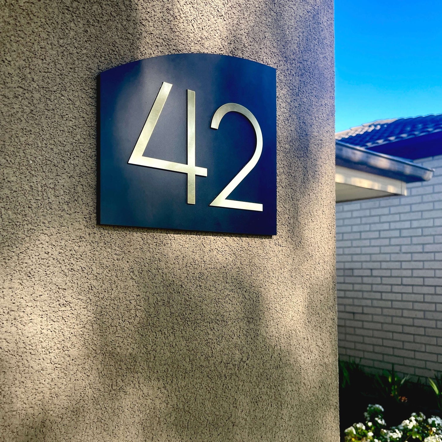 Modern Australian-made house number sign '42' on a textured wall, SW2 style, easy peel-and-stick installation.