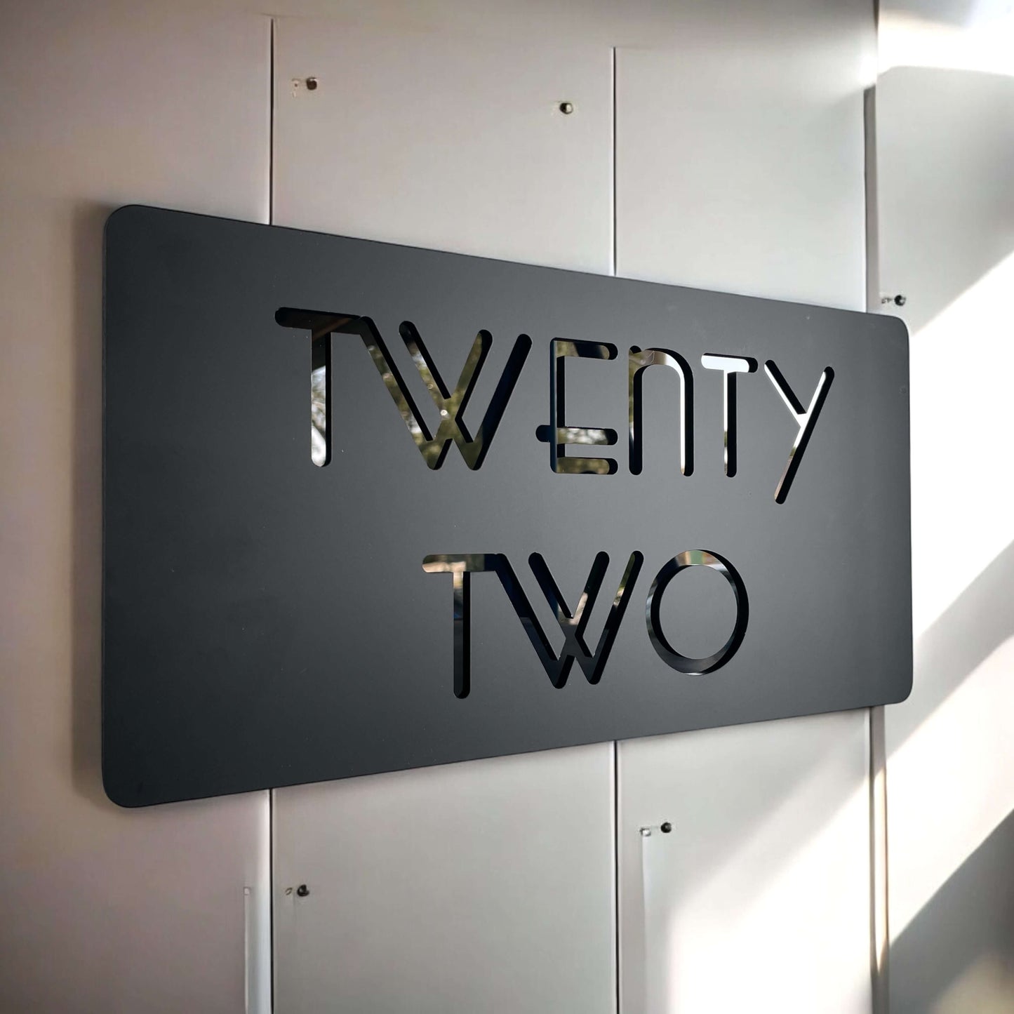 Modern black house number sign with cut-out 'TWENTY TWO'. Australian made, easy DIY install. SW2 house number sign.