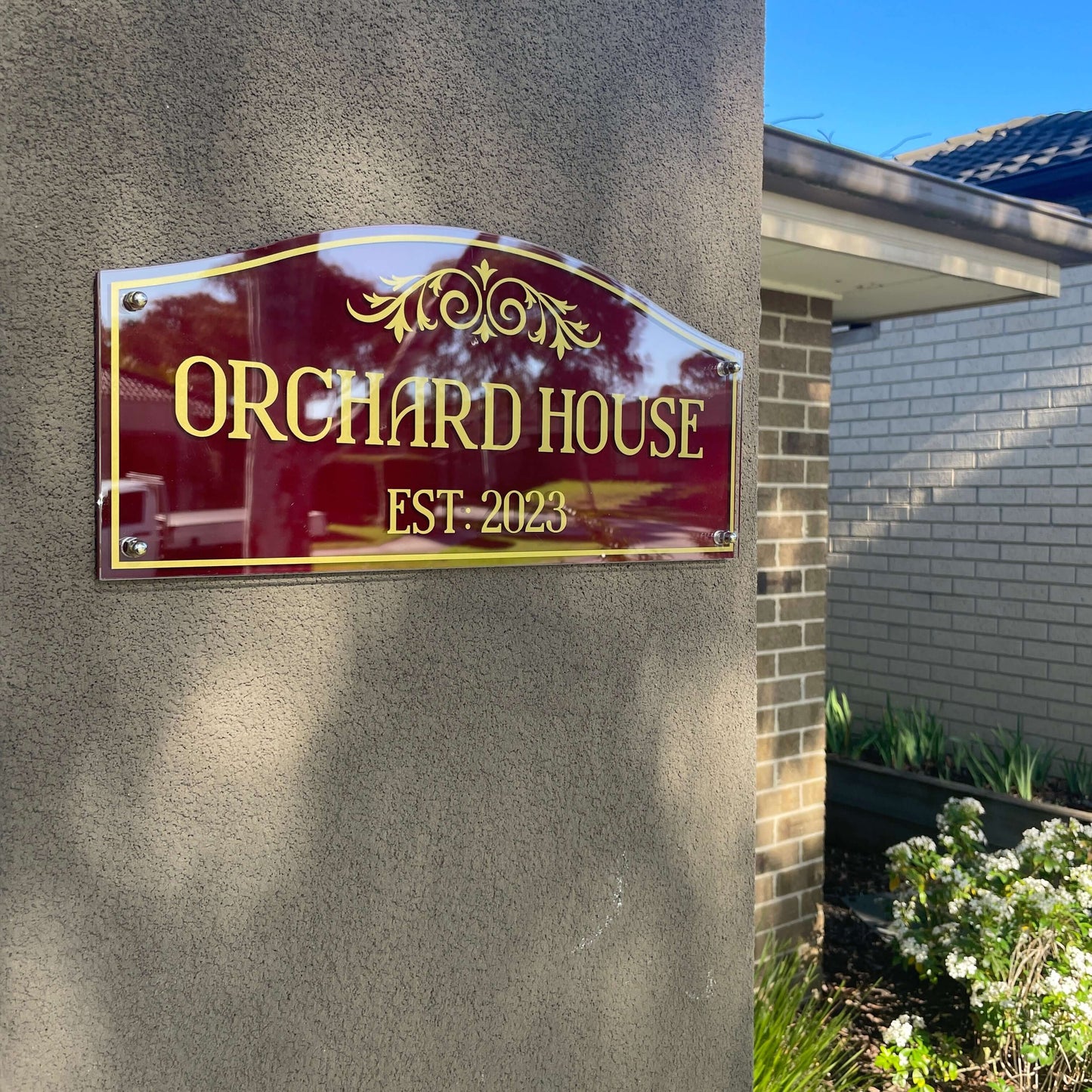 Heritage-style Orchard House sign mounted on exterior wall, vintage design with "Est. 2023" inscription.
