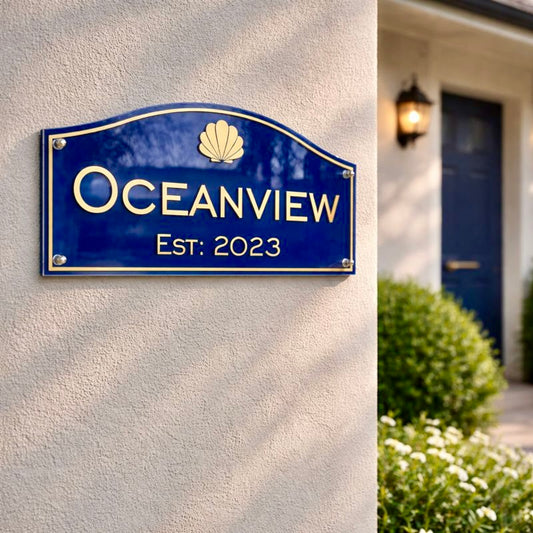 Heritage traditional acrylic house name sign in deep blue with gold vinyl lettering "Oceanview Est. 2023" mounted on a light rendered wall with classic Australian styling