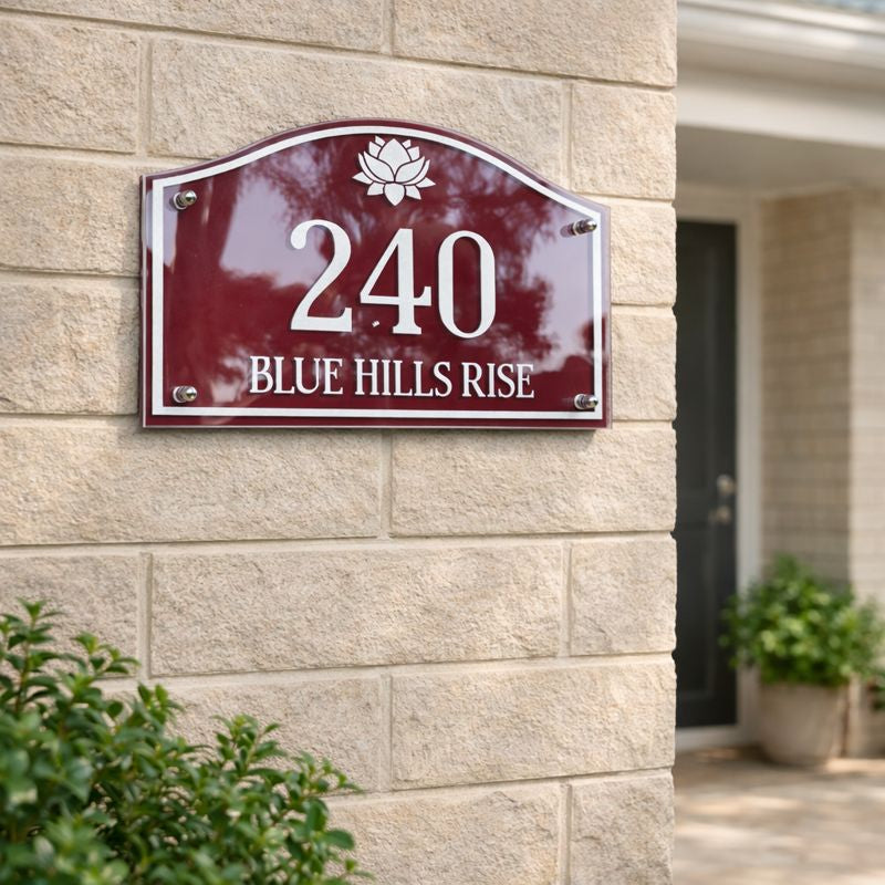 Heritage Petite compact house number sign in deep red with white numerals 240 and street name Blue Hills Rise mounted on a light stone wall