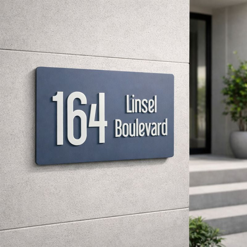 Legacy L3 3D rectangular house number sign in Stormy Grey showing 164 and Linsel Boulevard mounted on a light grey rendered wall