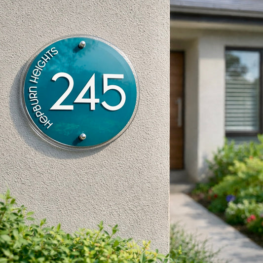Vogue 4 House number '245' on a teal circular plaque against a light gray wall with a white numbers and text.