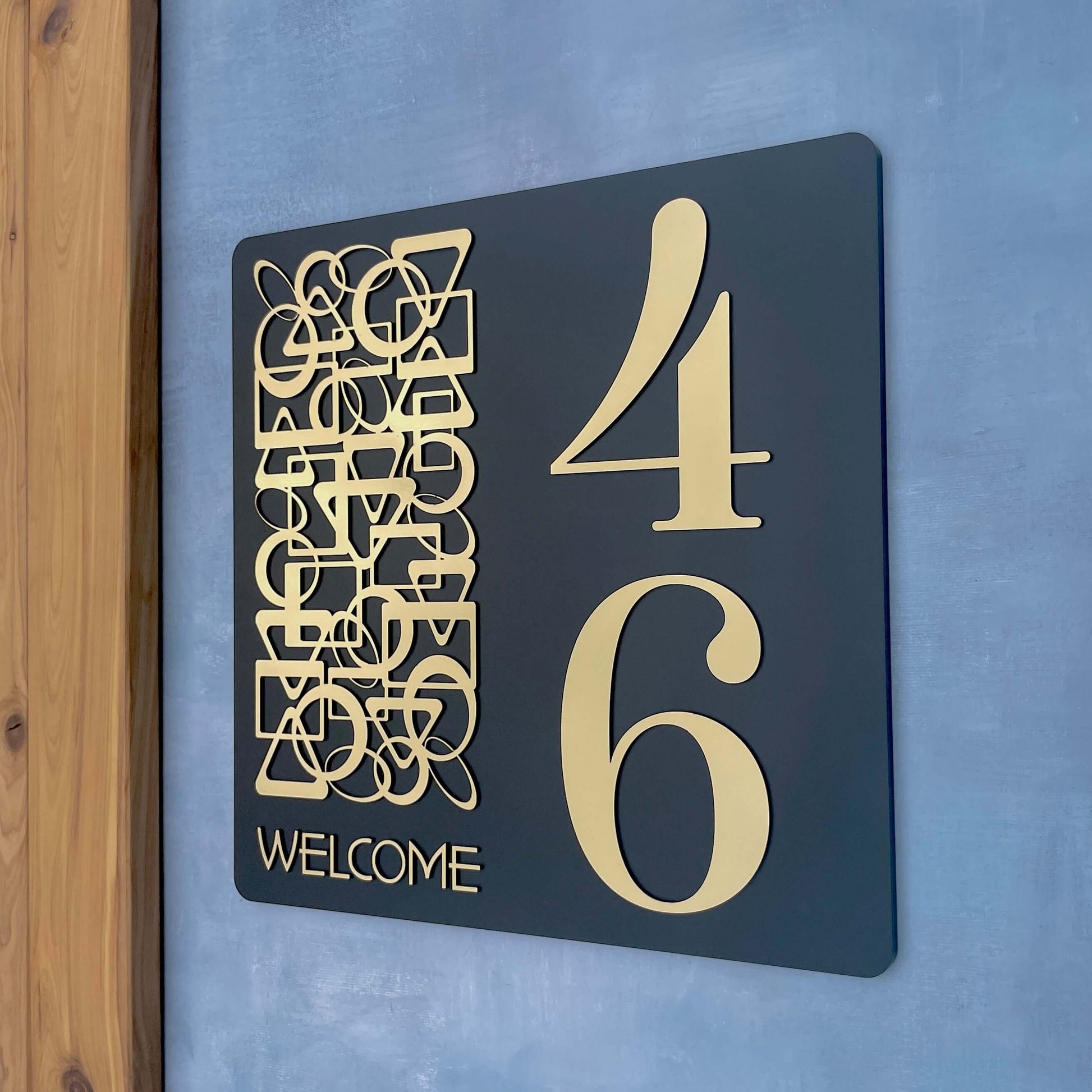 SW2 house number sign, showing numbers 4 and 6, with artistic design and 'Welcome' text, mounted on smooth wall surface