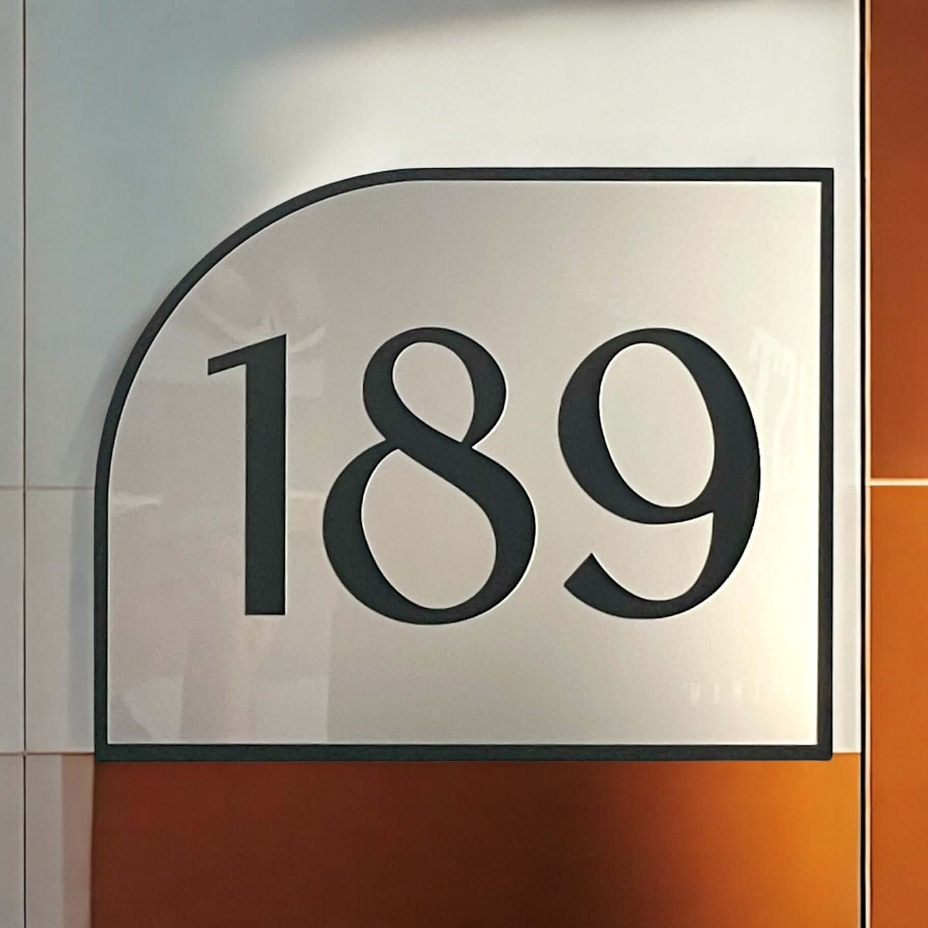 Modern house number sign '189' with a bold design, featuring a matte black acrylic frame and floating mount system for easy installation.