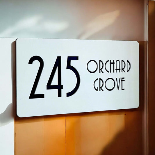 Nouveau 5 SW2 house number sign displaying '245 Orchard Grove' on a modern white background.