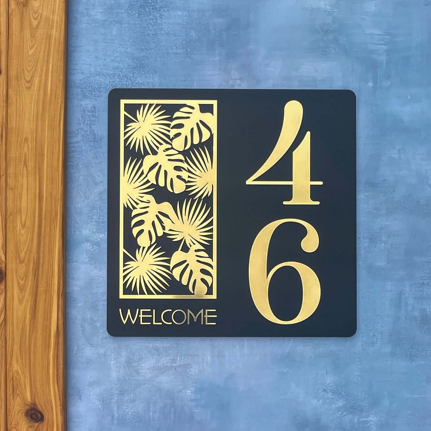 Stylish house number sign displaying '46' with palm leaf design and 'Welcome' text, suitable for smooth surfaces. SW2 house number sign.