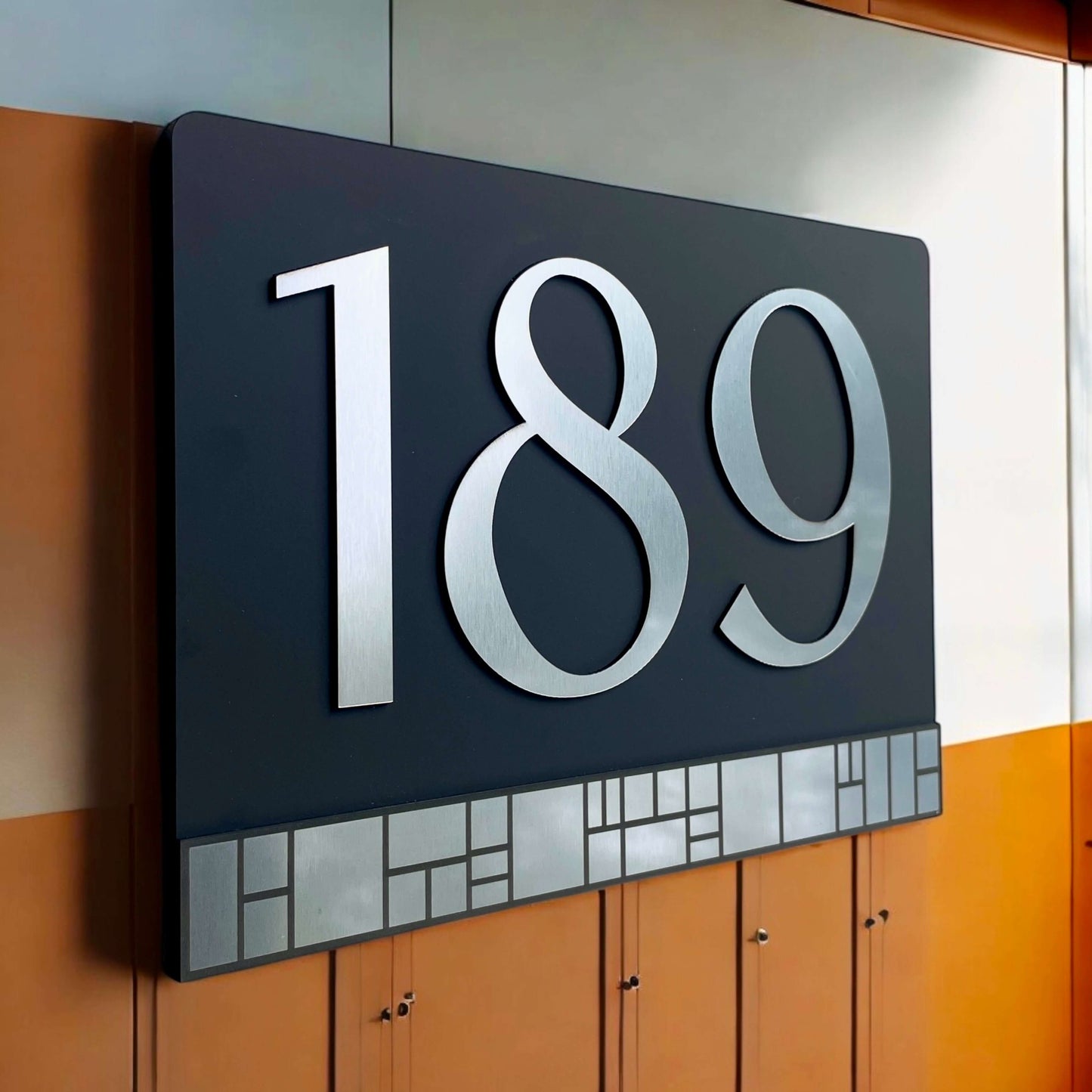 Australian made house number sign Elevate 4 with floating mount system, featuring silver numbers "189" on black acrylic.