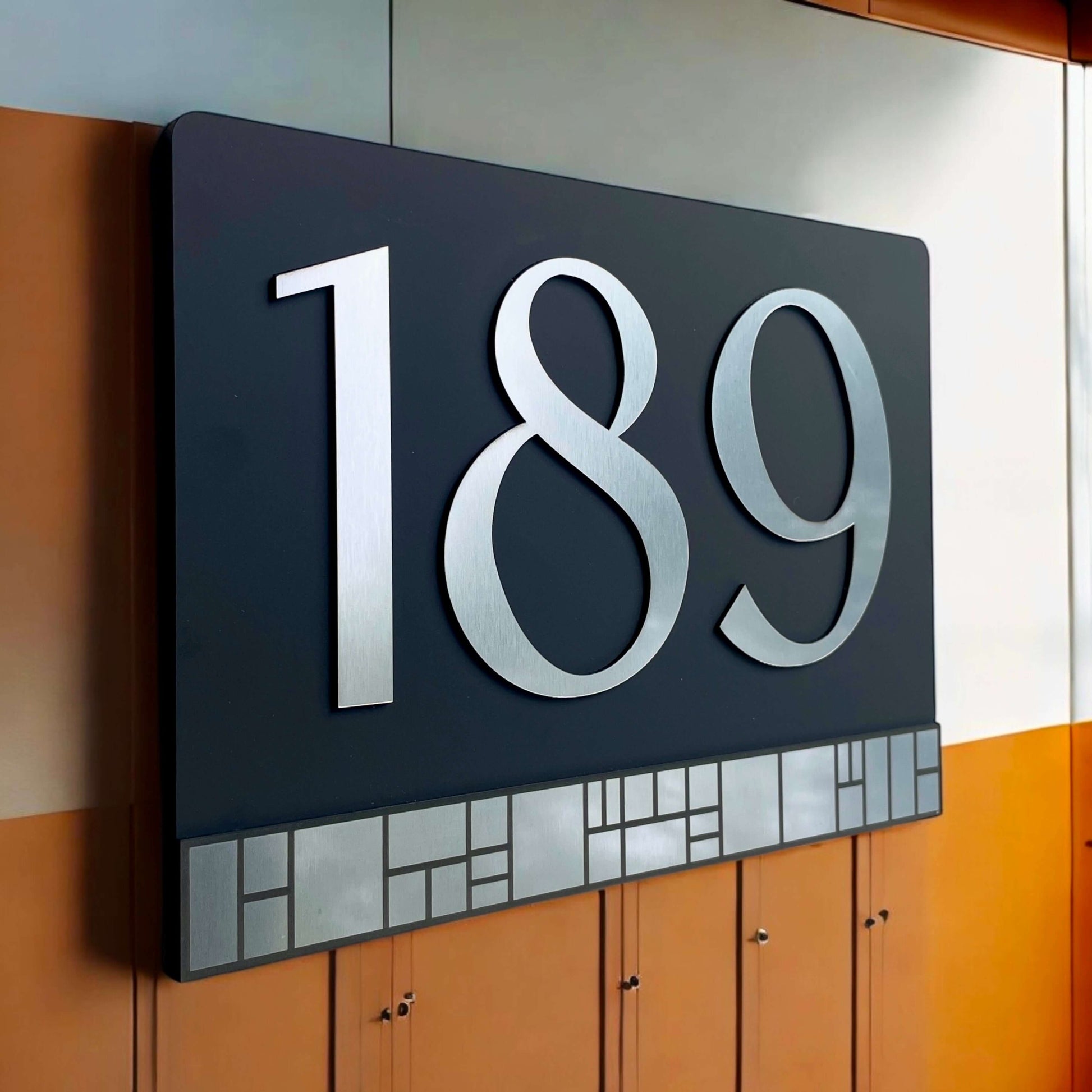 Australian made house number sign Elevate 4 with floating mount system, featuring silver numbers "189" on black acrylic.