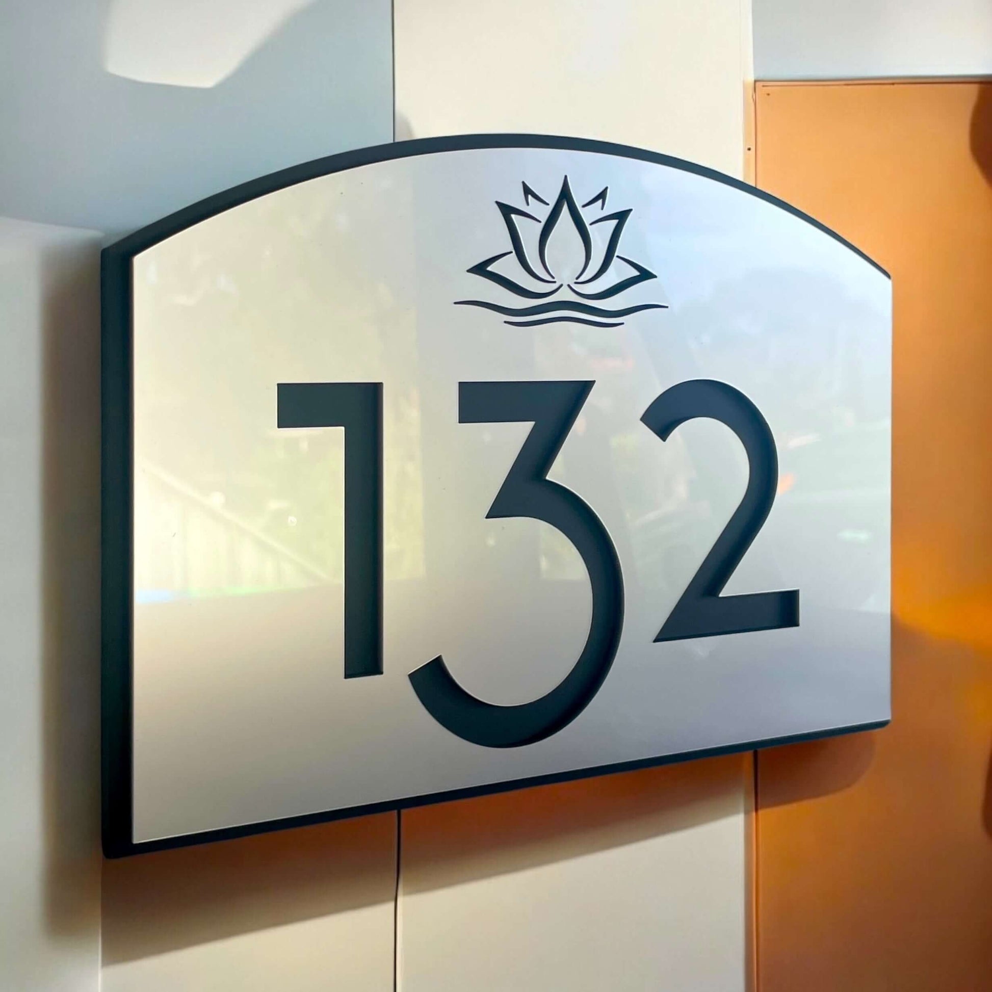 Stylish SW2 house number sign 132 in matte black and silver, with floating mount design, Australian made, on a modern wall.