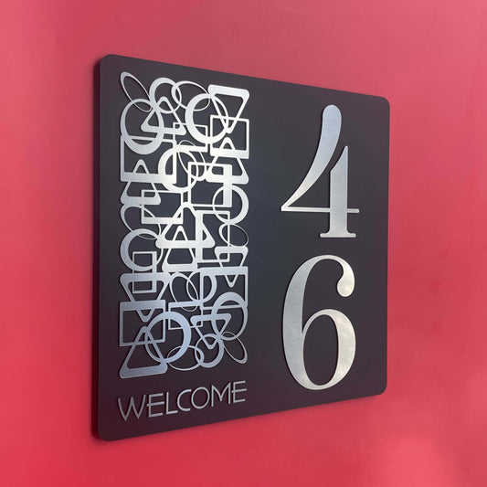 SW2 house number sign with abstract design and large silver numbers on a red wall background.