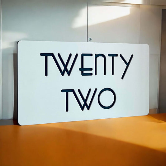 Stylish 'TWENTY TWO' house number sign with modern design on a smooth surface, suitable for DIY installation. Australian made.