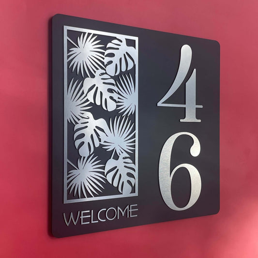 Modern house number sign "46" with palm design, black background, and silver accents, perfect for enhancing curb appeal.