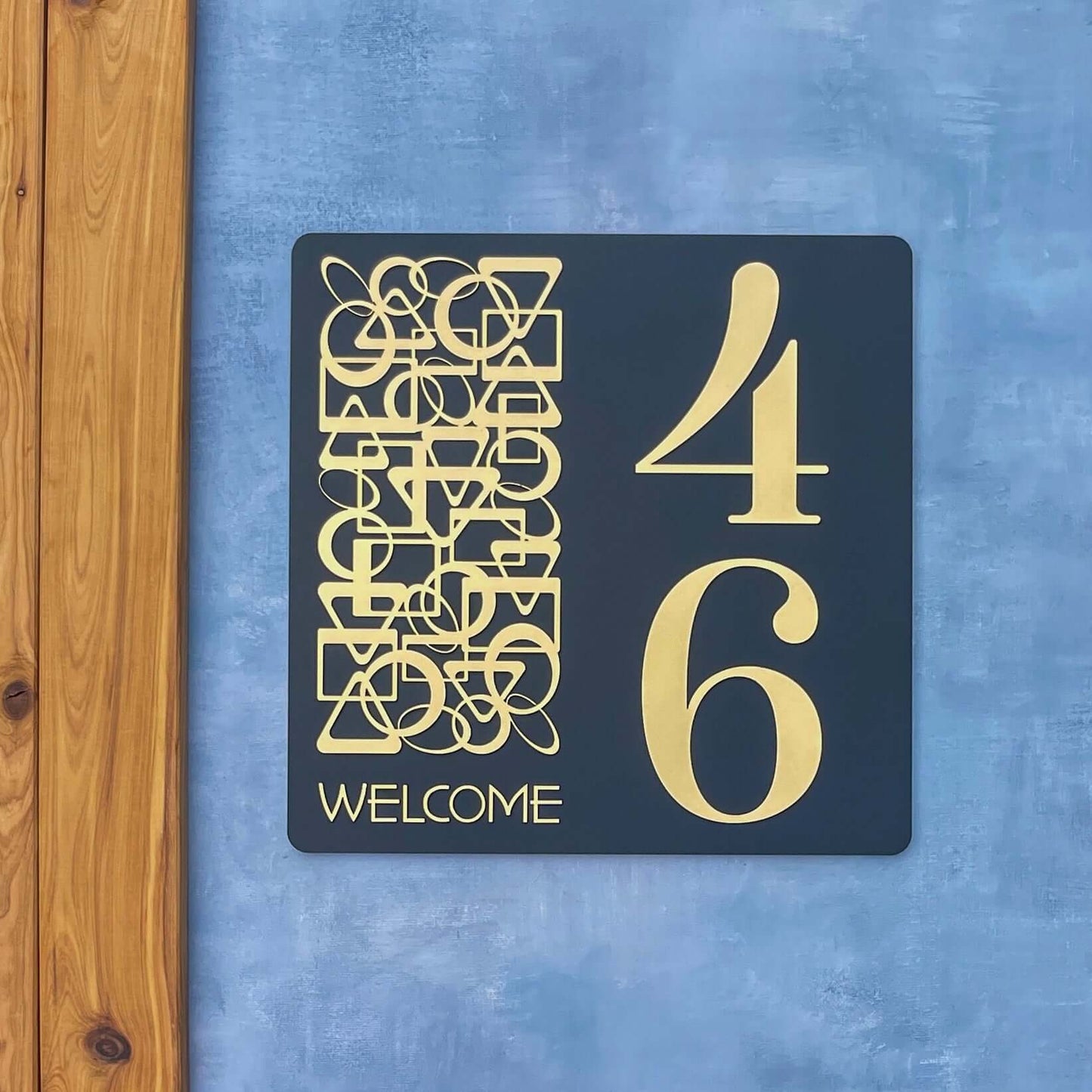 Modern SW2 house number sign with large '46' and artistic design on a blue wall. Australian made and weather-resistant.