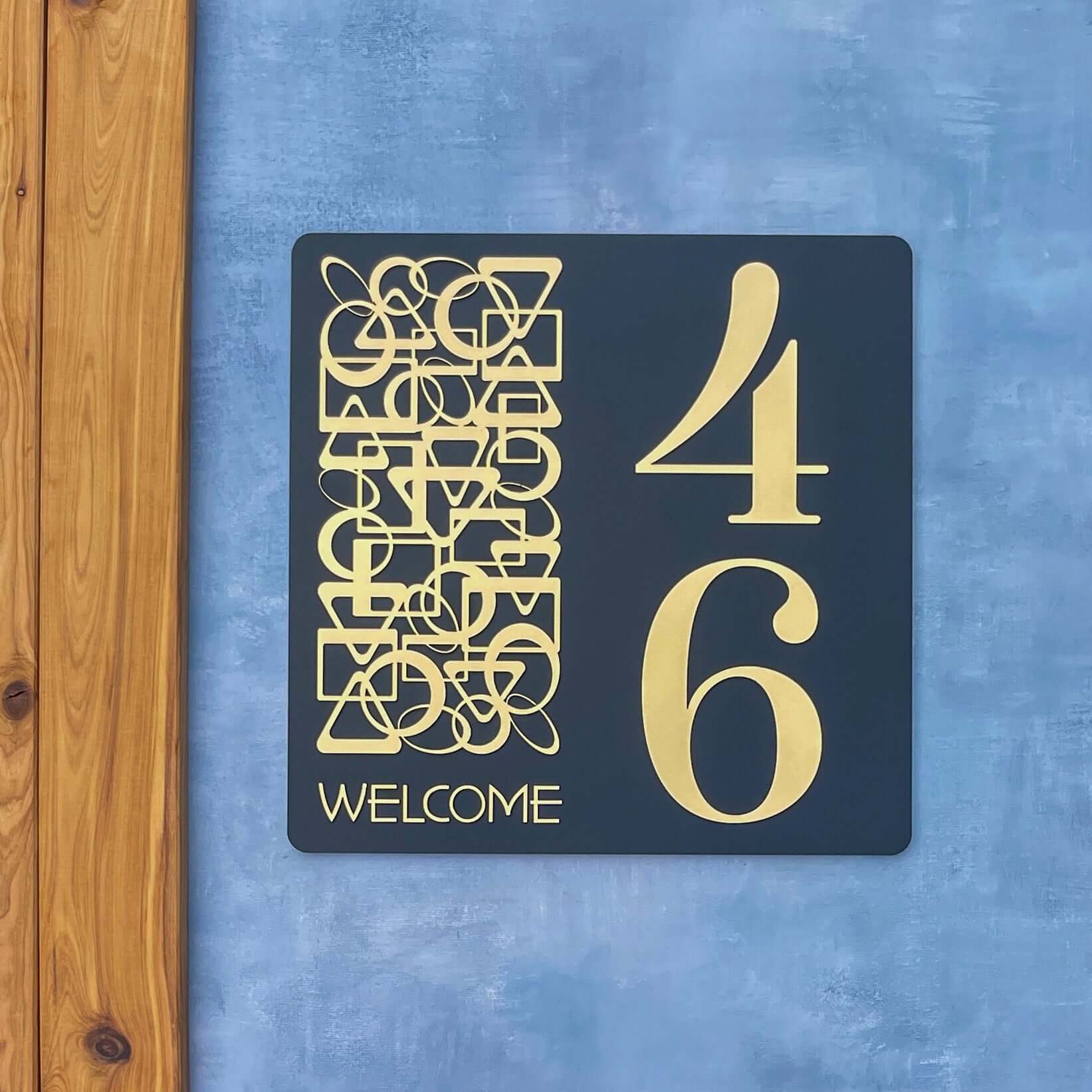 Modern SW2 house number sign with large '46' and artistic design on a blue wall. Australian made and weather-resistant.
